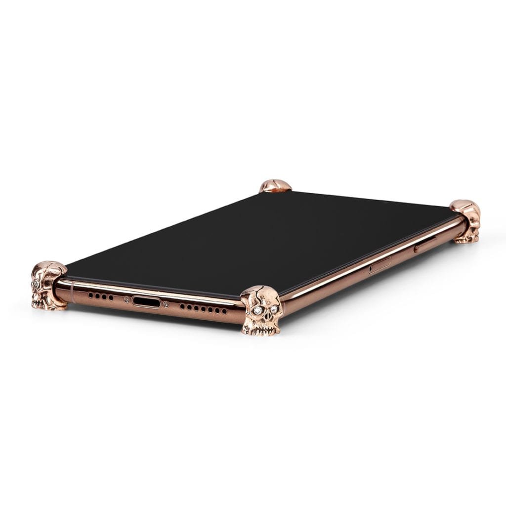 Rose Gold Skull ICONS installed on all four corners of a bare iPhone 11