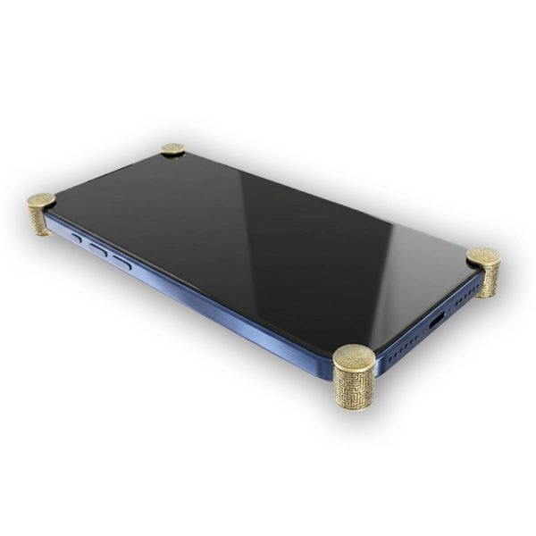 Gold Matrix ICONS installed on all four corners of a bare iPhone 17